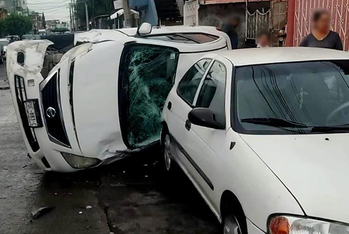 Auto choca contra un coche estacionado y vuelca, en el Infonavit Constituyentes de Uruapan