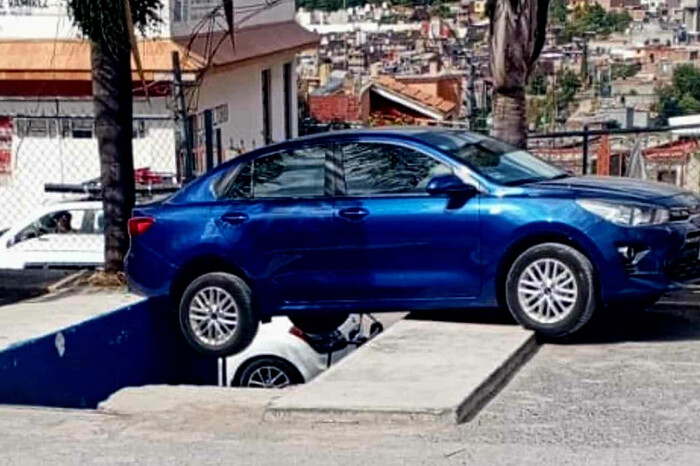 Auto mal aparcado se va hacia un desnivel en el estacionamiento de una tienda, en Morelia